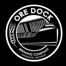 Logo with the brewery's name circled around an artist's depiction of a cargo ship and the eponymous ore dock