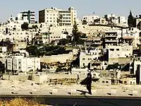 Member of the Ultra-Orthodox Jewish Community Walking in front of Silwan. Many members of the Ultra-Orthodox Community travel to and live in Jerusalem