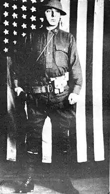 Pfaus in US Army uniform standing in front of an American flag