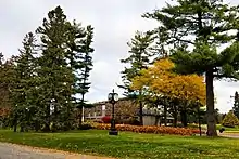 External view of a two-storey stone and cement building surrounded by trees