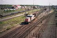 A diesel locomotive (class Dr16) hauling lumber.