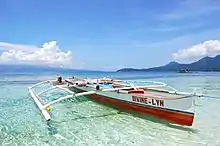 An outrigger canoe over the clear waters of White Island