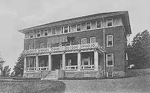 A three-story brick building on a hill.