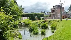 The pond, cross and town hall in Choqueuse-les-Bénards