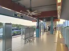 View of the island platform with half-height platform barriers separating passengers from the tracks