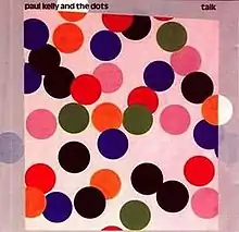 Scattered range of large coloured circles mostly red or black. The background in pink. Artist name is at top left with album name at top right.