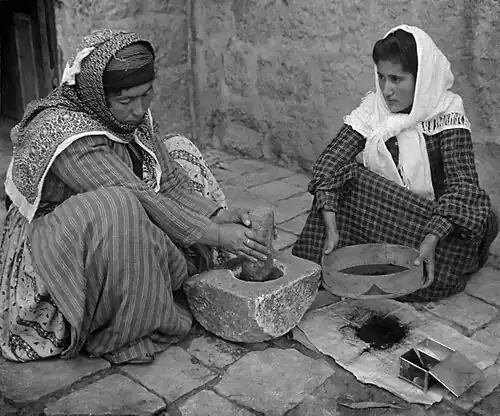 Image 101905 Stereoscope. Original caption reads: The native mode of grinding coffee, Palestine.Credit:American Colony Jerusalem (edited by Durova)