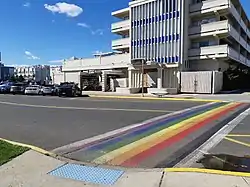 White building with rainbow crosswalk out front