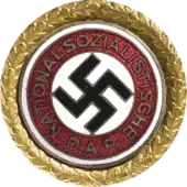 a circular golden badge with a central swastika