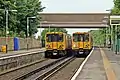 Merseyrail Class 508s pass at the station.