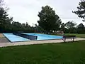 Wading pool, with swings and other amenities in the background.