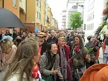 Large group of smiling people, one taking a selfie