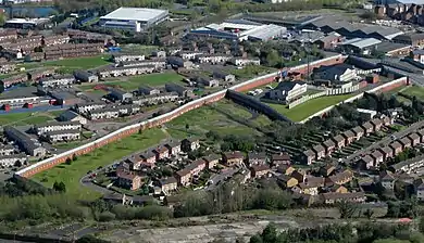 A 5.5m high peace line along Springmartin Road in Belfast, with a fortified police station at one end