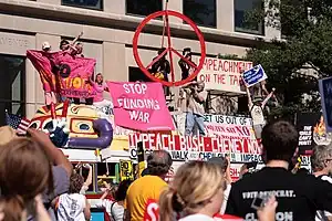 A bus festooned with peace signs, symbols and demonstrators