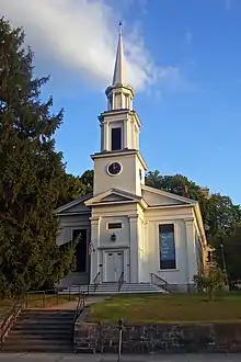 Front view of Peekskill Presbyterian Church in evening light, showing retaining wall in front