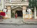 A monk standing in front of the temple gate.