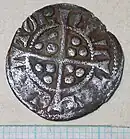 dull, silver coin with a cross in the centre