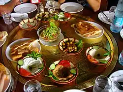 A large, round tray with a variety of small dishes