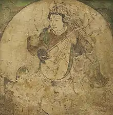 An apsara (feitian) playing pipa, using fingers with the pipa held in near upright position. Mural from Kizil, estimated Five Dynasties to Yuan dynasty, 10th to 13th century.