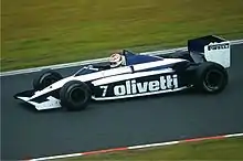 A mid-engined single-seater racing car with large aerodynamic wings