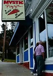 Tourists look into the famous pizza parlor in Mystic.