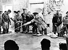 The second battle of Libya. Before zero hour; the Brigadier commanding tank units in Tobruk instructs tank commanders on the operations, using a sand table for demonstration purposes.