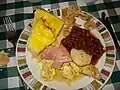 Breakfast at a sugar shack, featuring fève au lard, oreilles de crisse, eggs, ham and potatoes.