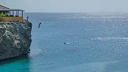 A person jumping of the cliffs near Playa Forti