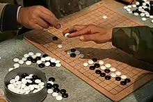 Image 18Go players demonstrating the traditional technique of holding a stone (from Go (game))