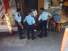 Police Tactical Unit officers stop to check a suspect.