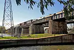 An old railway bridge on stone pillars.