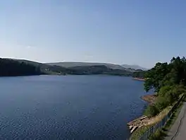 A lake surrounded by trees and hills