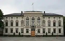 A white stately building seen across the river