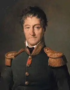 Painting of a long-faced man with wavy brown hair. He wears a dark blue military coat with gold epaulettes.