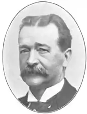 three-quarter image of older white man with mustache