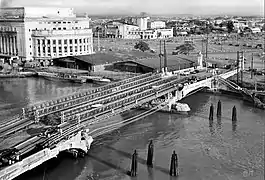 A bridge being reconstructed with cars passing by