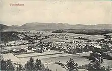 Aerial photograph of a small town surrounded by mountains and agricultural fields.