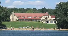 Big hotel with beach on lake.