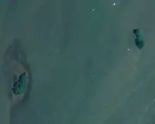 An aerial photograph of two small islands separated by water