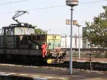 A railroad worker riding on the side of an electric shunting locomotive in Prague, Czech Republic