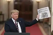 Trump displaying the front page of The Washington Post reporting his acquittal by the Senate