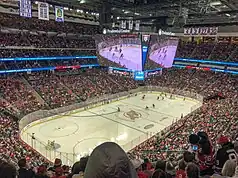 A photograph showing a hockey game being played in an arena.