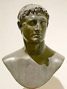 Dark stone bust of a young man wearing a headband