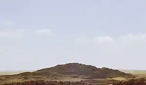 Ruined heap of brownish stones in a sand desert