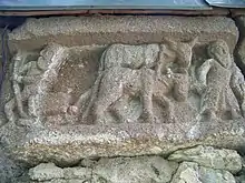 Workers position a large stone on an ox-drawn sledge.