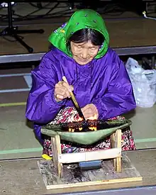 An Inuit woman tending a qulliq, a traditional whale, or seal, oil lamp (Nunavut, Canada, 1999)