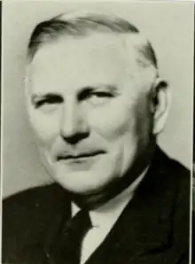 A black and white photograph of a white man in a suit