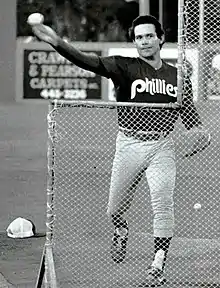 A man in light baseball pants and a dark jersey