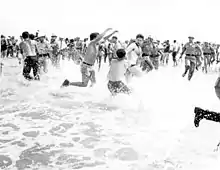 Black and white photograph of segregationists fighting on a beach