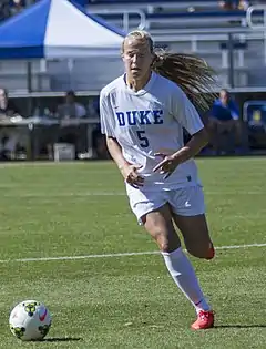 photo of Quinn wearing white and blue soccer kit while playing for the Duke Blue Devils in 2014